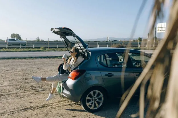 Meeting friends becomes difficult without transport Woman sitting in a car boot