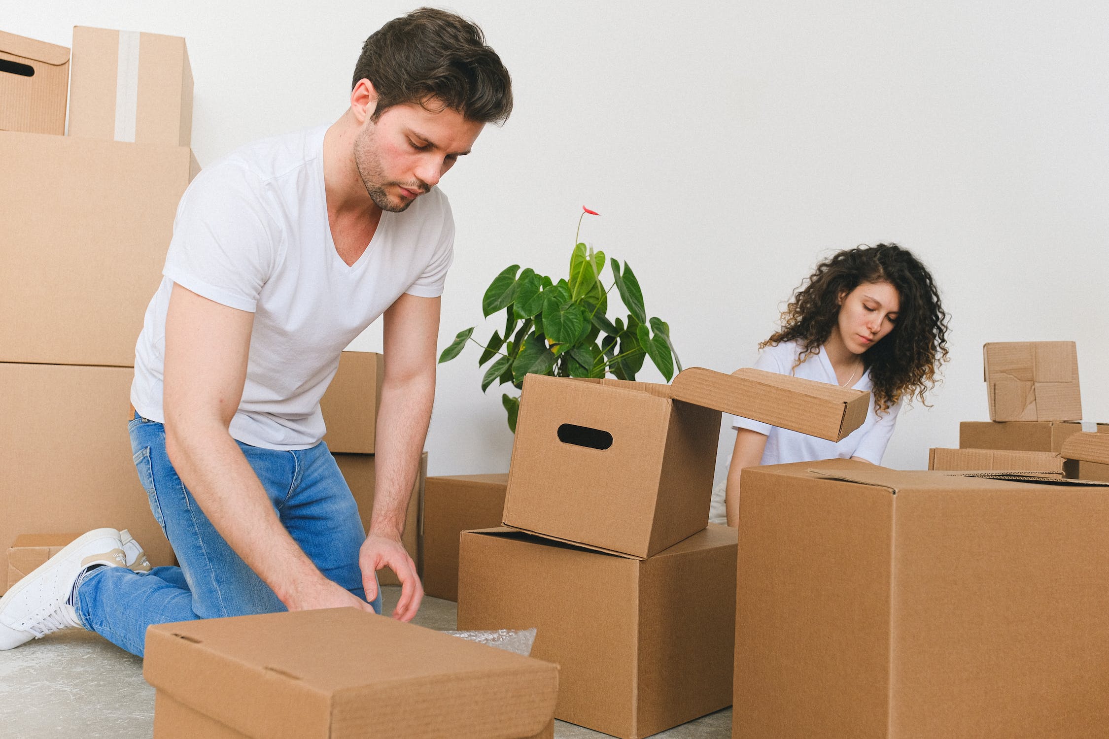 Two people filling boxes with stuff.