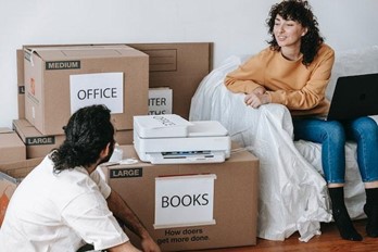 A couple surrounded by packed boxes.