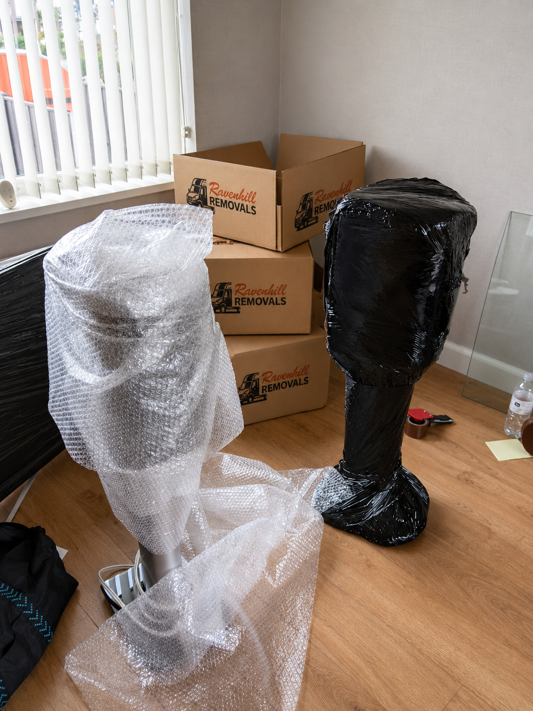 Professional packing of unboxed speakers using bubble wrap and stretch wrap by Ravenhill Removals Speakers protected with bubble wrap and stretch wrap ready for a house move, with Ravenhill Removals moving boxes in the background