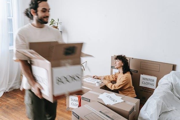 A young couple is packing things into boxes