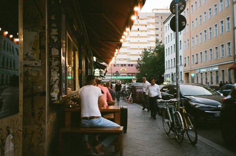 Urban neighborhood, café, people outside, bicycles, buildings