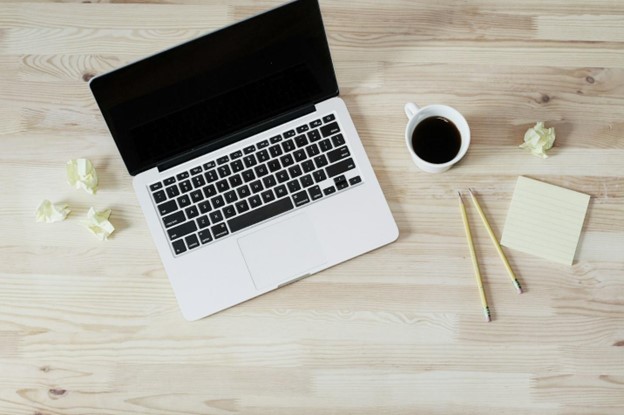 Laptop on desk next to coffee cup