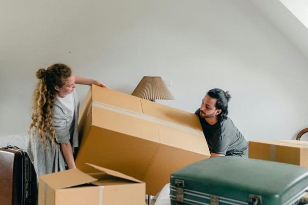A couple lifting and moving boxes